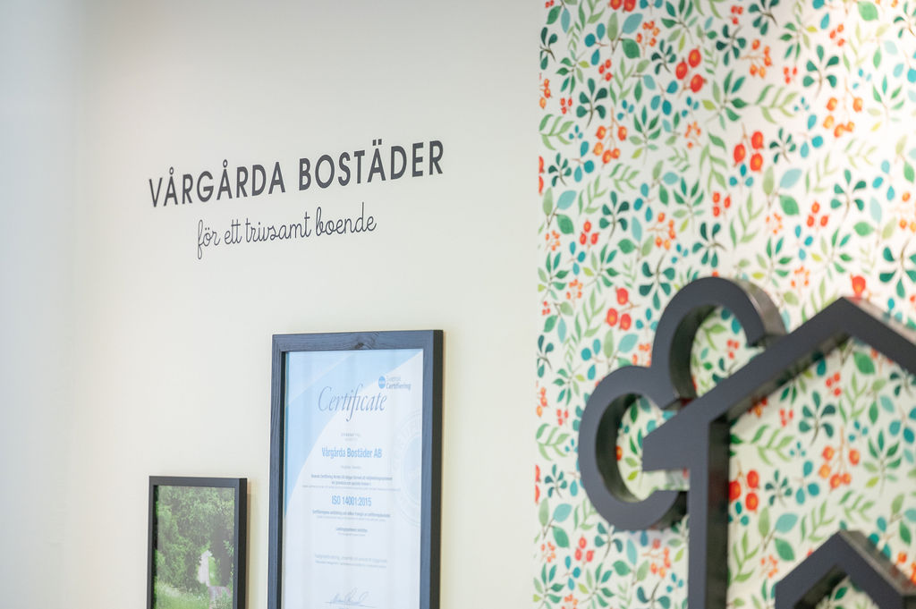 Bild på logga, blommig tapet, tavlor med miljöcertifikat