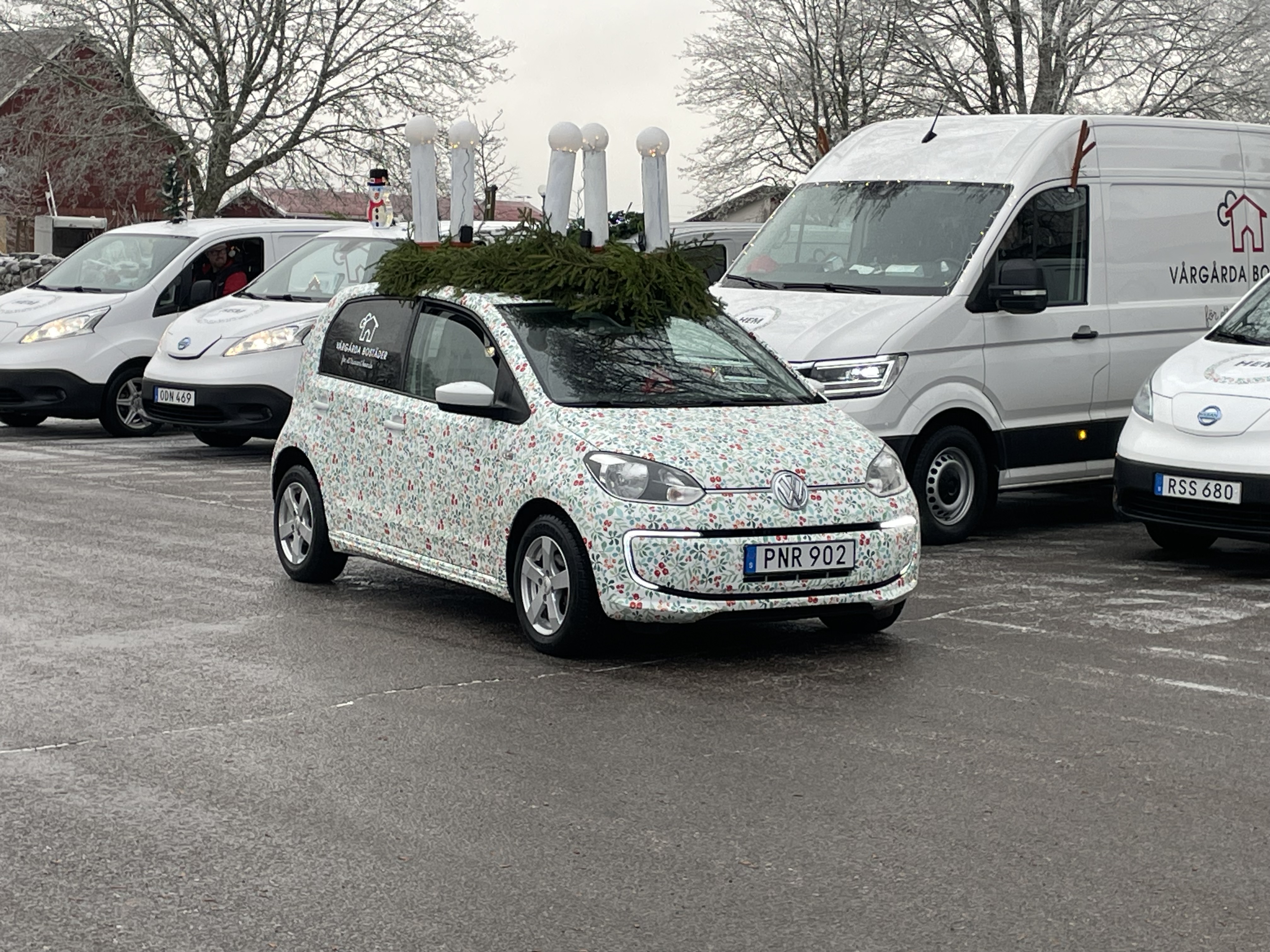 Blommig bil med luciakrona på taket.